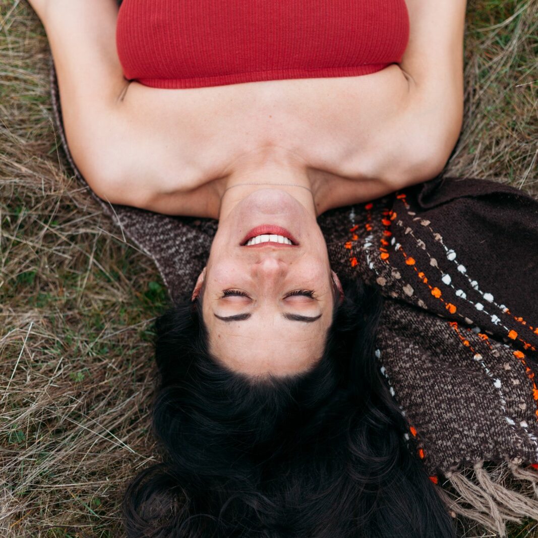 Minda Lane, a creative spirit laying down in the grass.