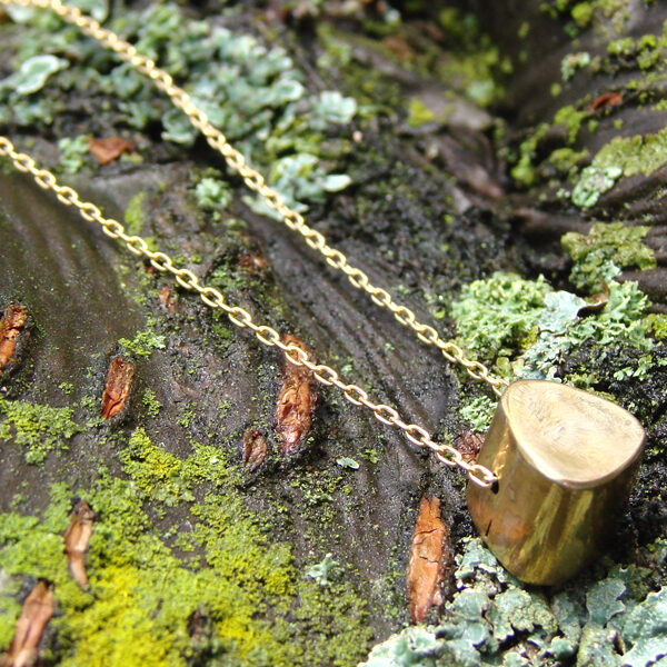 A unique gold necklace handcrafted by Minda Lane, adorned with delicate moss.